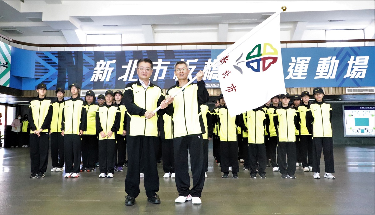 教育局副局長劉明超（左）授旗予新北市「2023年全國小學田徑錦標賽」代表隊，新埔國小校長陳維穎（右）代表接受。 圖：新北市教育局提供