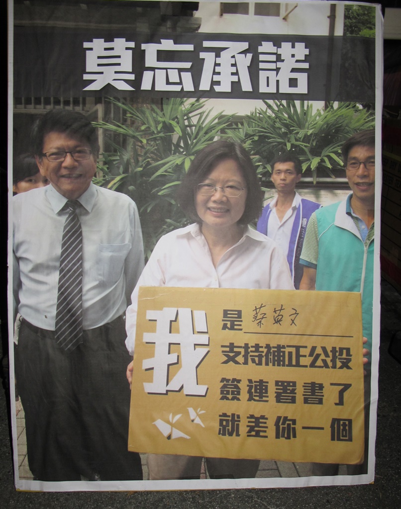總統候選人蔡英文2015年在屏東造勢場合，笑得燦爛，手持「我是蔡英文，支持補正公投，簽署連署書，就差你一個」的看板。 圖：島國前進提供