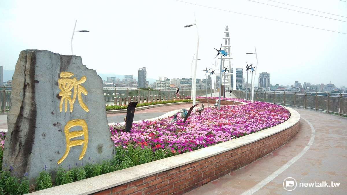 新月橋各色花朵開放，帶來些許春天氣息。 圖：新北市提供