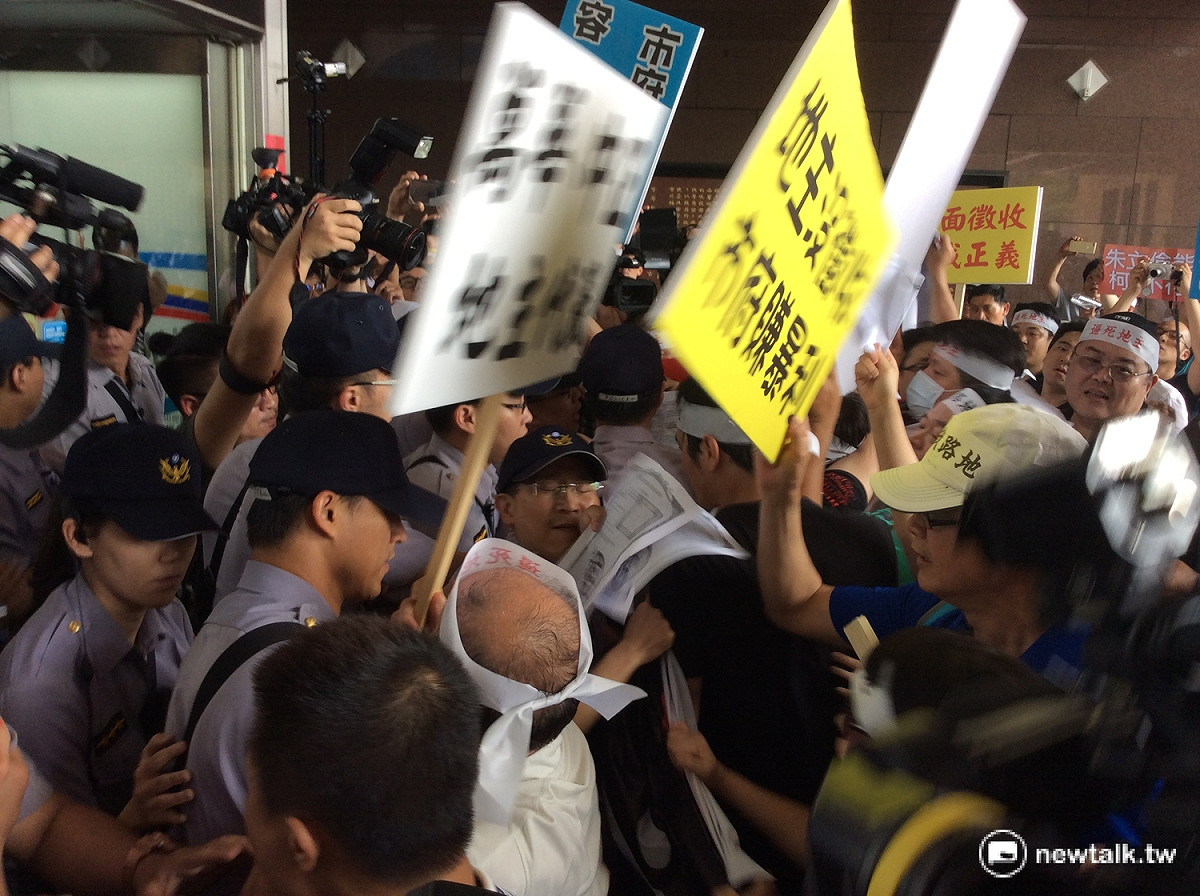 抗議指揮一聲令下大喊「衝！」，十多名地主向市政大樓大門飛奔，與門口警力發生推擠衝突 圖：程士華/攝