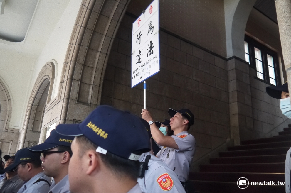 警方舉牌要求民眾解散。 圖：鍾孟軒/攝