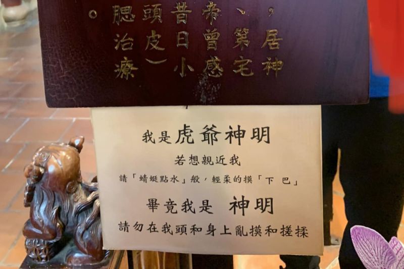 信徒似乎將台南興濟宮的虎爺當貓在疼愛，於是廟方貼出公告，希望眾人輕摸就好。 圖／朱宥勳  臉書