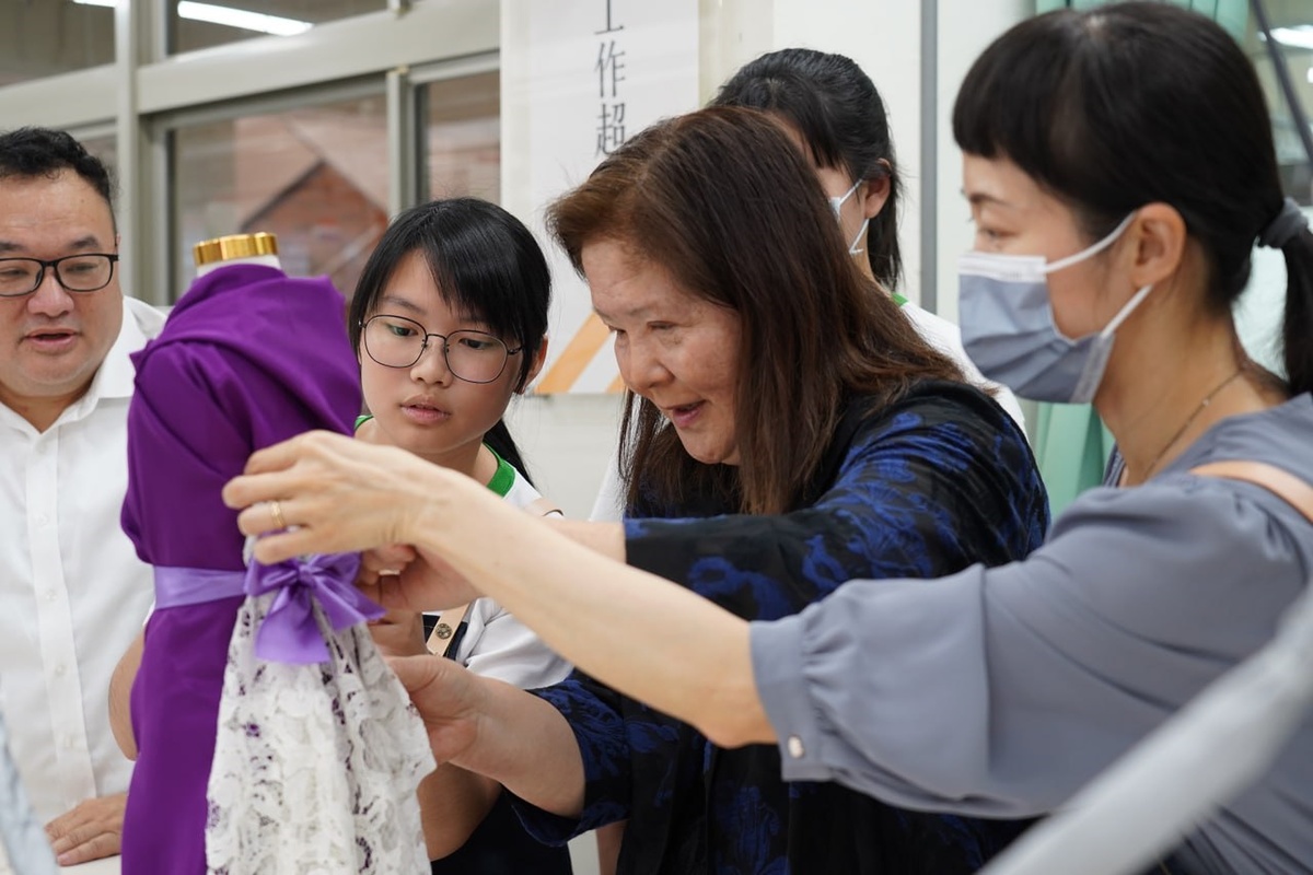 魏虹與學生共同討論、創作，實際將布料抓褶出構思的創意款式，在人檯上展現設計風采。 圖：新北市教育局提供
