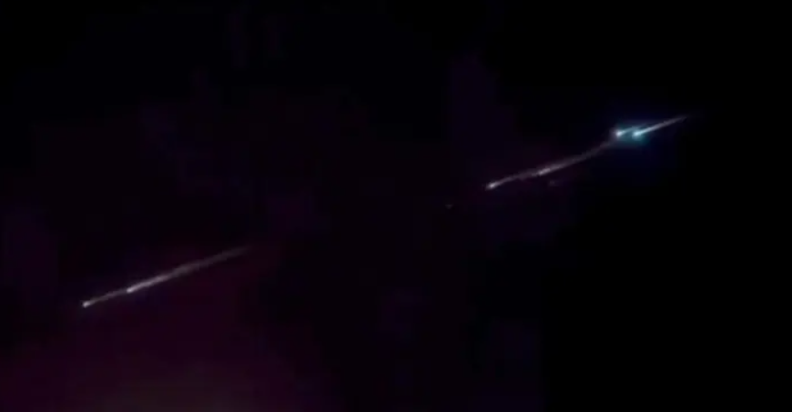 漆黑的夜空中，多個閃著藍白色光的物體依次劃過夜空，還拖著白色的長尾巴。 圖：翻攝自大象新聞