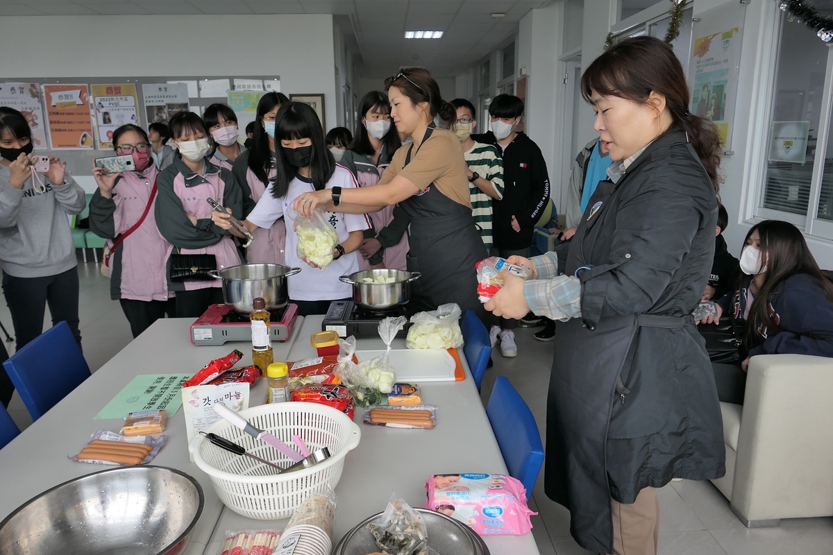 醒吾科大應英系老師金聖姬（右起）及張秀任讓學生親自參與煮辣年糕，從實作的過程中學習韓語，每位學生吃了都讚不絕口。 圖：吾限熊報社潘奕成/攝
