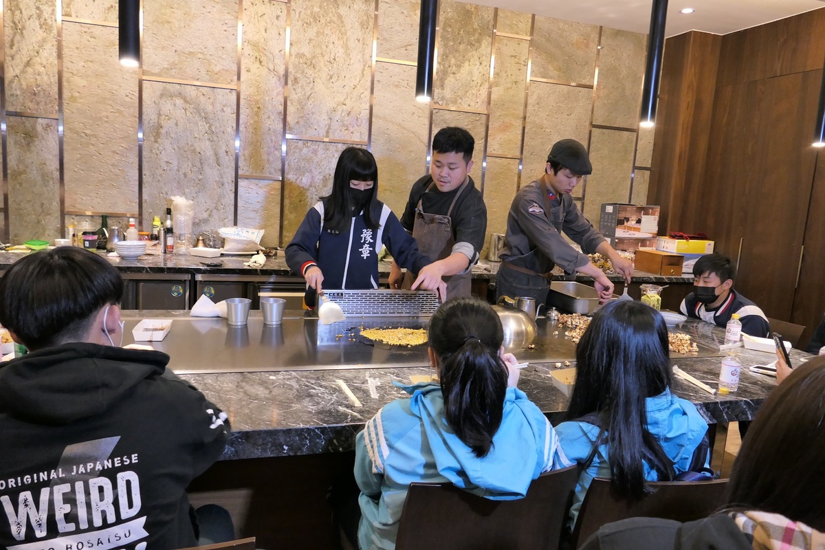 醒吾科大餐旅系老師朱俊松在鐵板燒教室帶領學生製作爆米花，學生驚呼鐵板也能爆米花。 圖：吾限熊報社潘奕成/攝