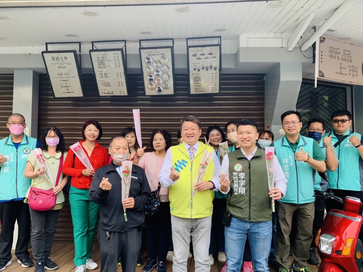 民進黨新北市黨部今(11)日上午在林口舊街舉辦「溫馨五月 我愛媽咪」活動，由主委何博文率領黨部黨工來到商圈市場發送康乃馨，向媽媽們表達感謝與祝福。 圖：民進黨新北市黨部提供