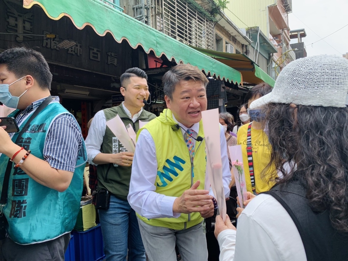今天新北市黨部準備了1500朵康乃馨與2000張母親節貼紙，由何博文、李宇翔遞送給商圈市場的店家與民眾。 圖：民進黨新北市黨部提供