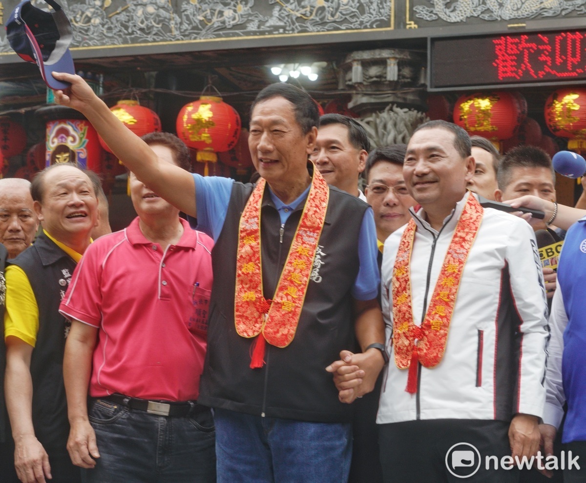 郭台銘握著侯友宜的手，脫帽向在場信眾揮手。 圖：張良一/攝