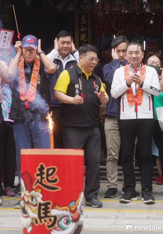 點燃起馬炮後，郭台銘和現場信眾一起摀著耳朵，但侯友宜老神在在的手持馨香祝禱。 圖：張良一/攝