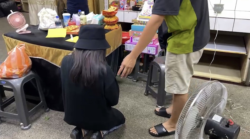 台南市8日發生休旅車撞擊斑馬線上母女，造成3歲女童不治，母親重傷送醫，肇事的杜姓孕婦（左）13日前往台南市立殯儀館祭拜已逝女童，女童父親以杜女有孕在身，請她起來。 圖：中央社（翻攝照片）