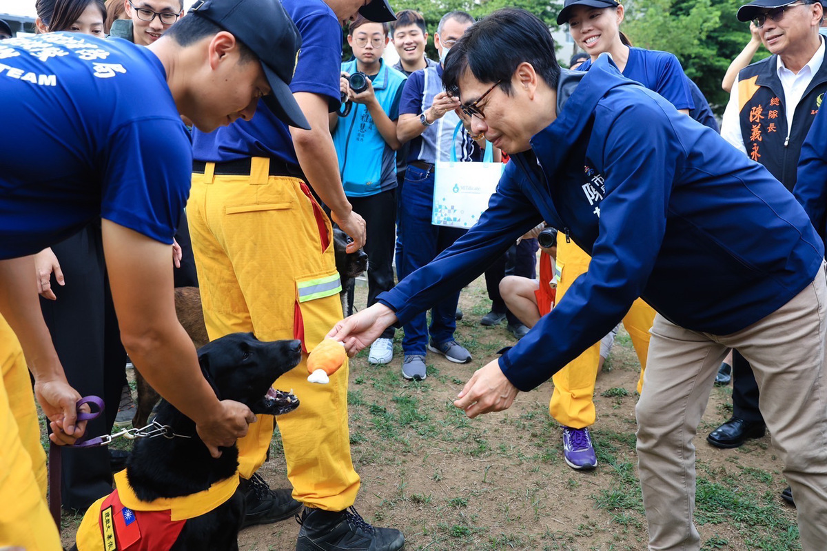 陳其邁(右)與救援犬互動。 圖：高雄市消防局/提供