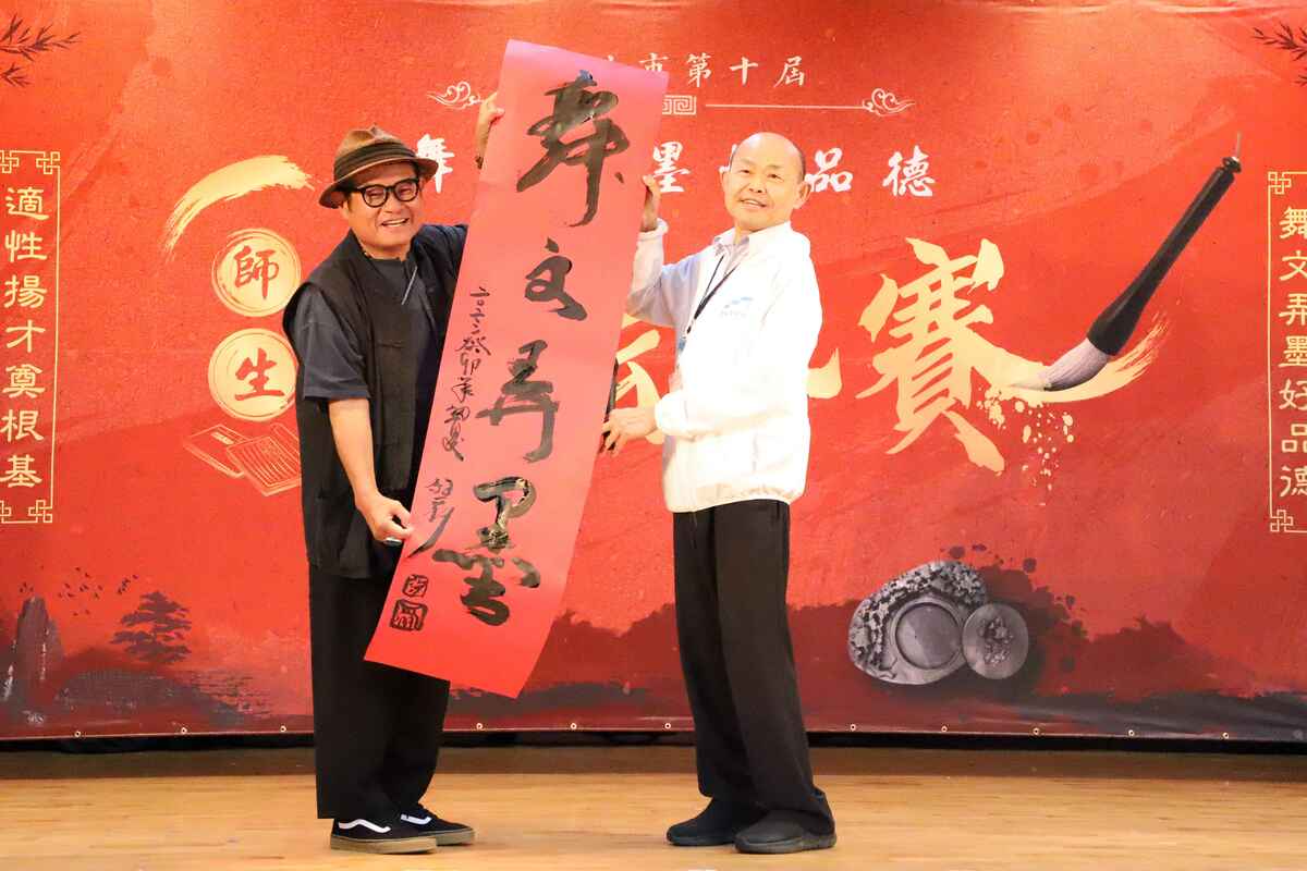 藝人許效舜（左）提字舞文弄墨與教育局副局長歐人豪（右）合照。 圖：新北市教育局提供