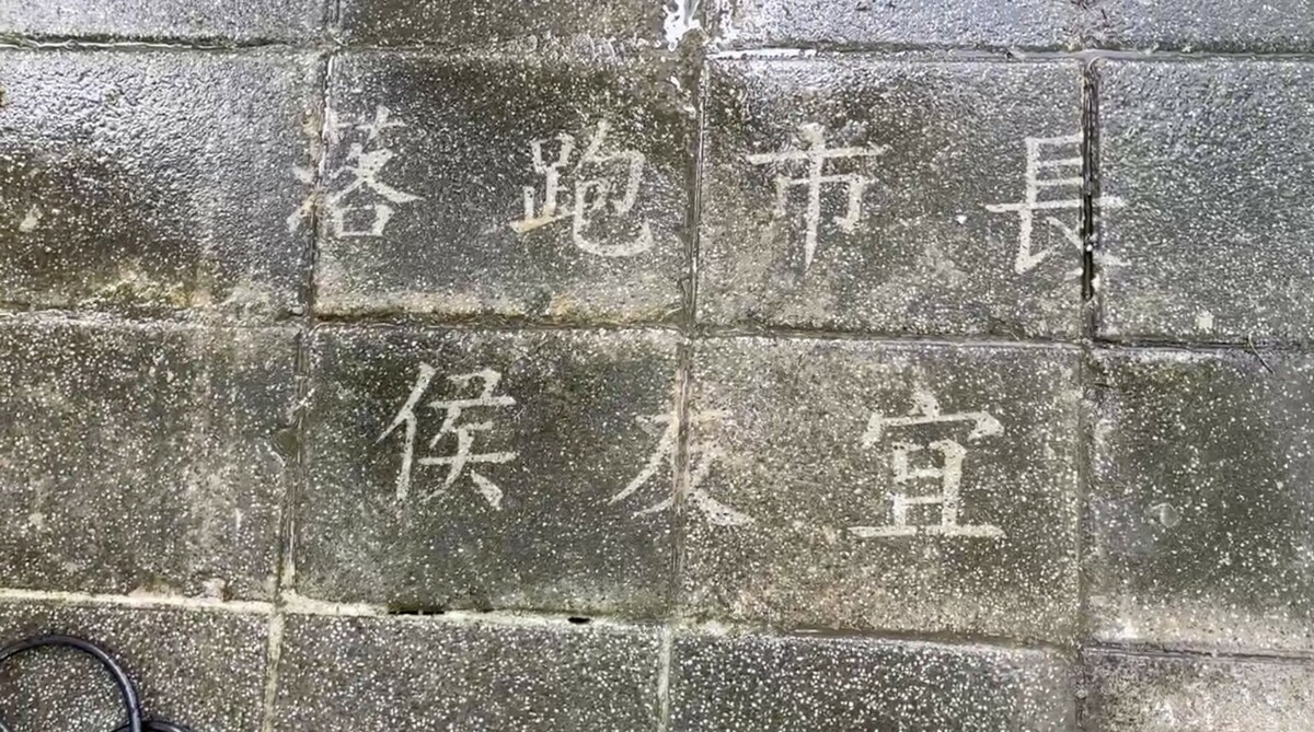 公投護台灣聯盟成員在新北市政府前進行洗地板行動，並洗出「落跑市長侯友宜」字樣抗議，被警車帶回派出所訊問。 圖：公投護台灣聯盟提供