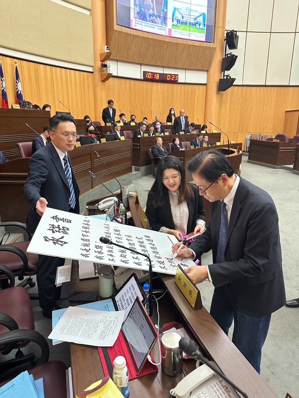 張善政在承諾書上簽名，並補上「全力落實對市民的承諾」這句話，強調自己會把市長任期做完。 圖：魏筠/提供