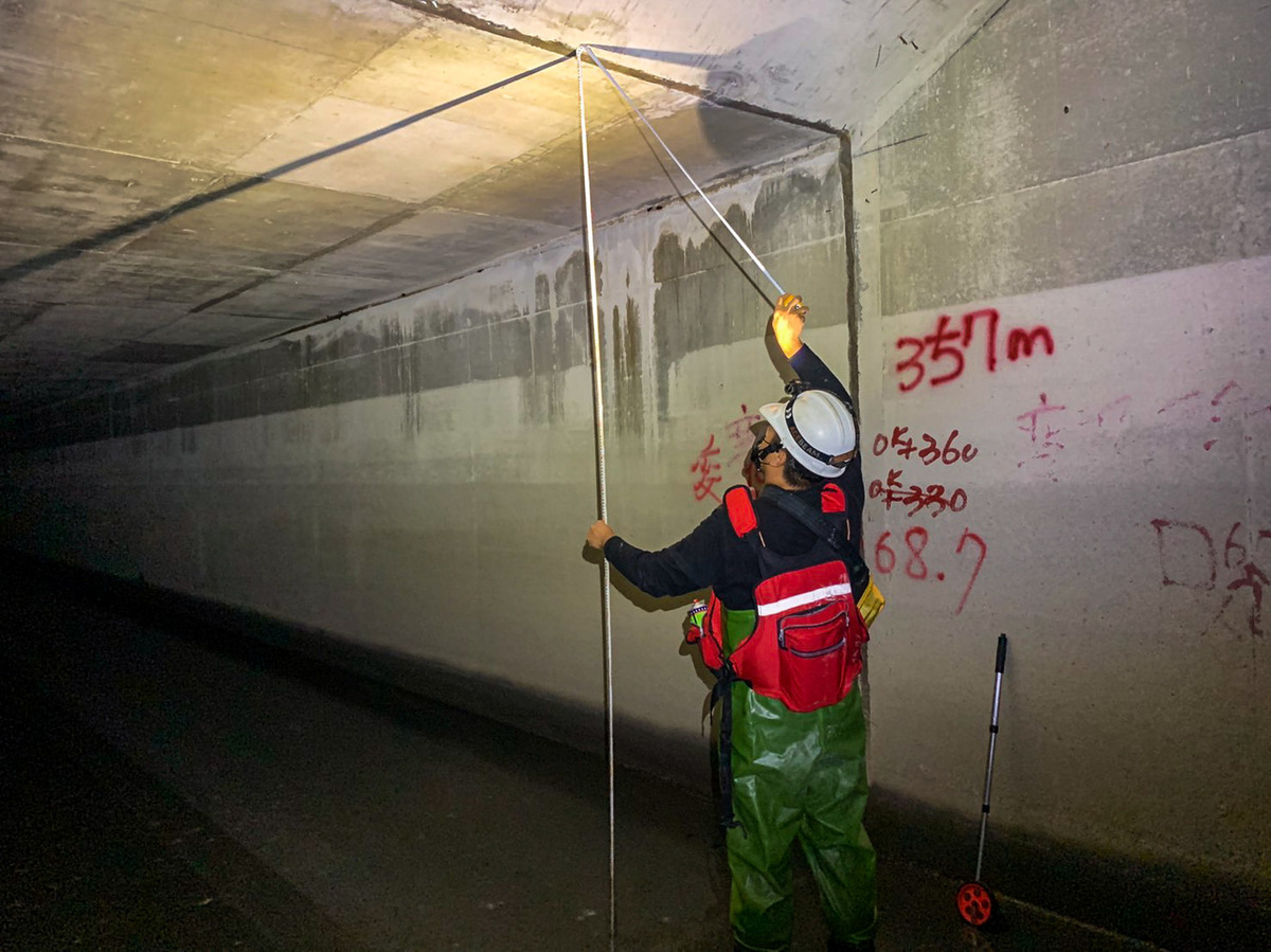 檢查人員有時需要進入昏暗且潮濕的箱涵裡進行量測。 圖：新北市水利局提供