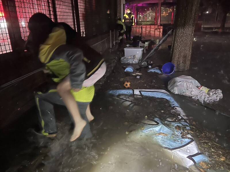 新竹縣竹北市住家淹水，消防人員協助民眾脫困。 圖：竹縣消防局提供