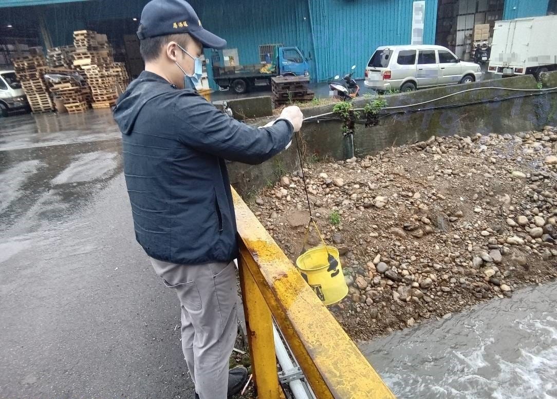 稽查人員採集水樣。 圖：新北市環保局提供