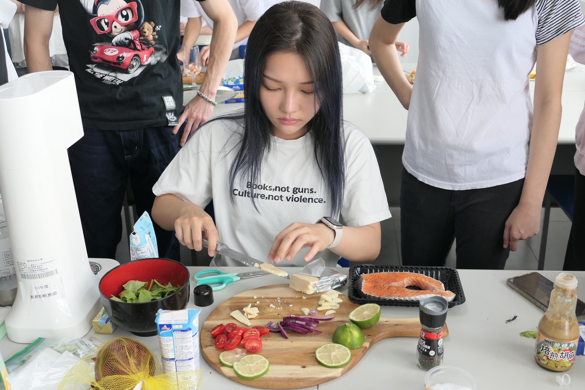 第二組主廚林語頡，製做主菜「歡迎來托斯卡納」，由乾煎鮭魚搭配菠菜、再用日曬番茄和帕瑪松起司所製成的醬汁。 圖：吾限熊報社楊政道攝