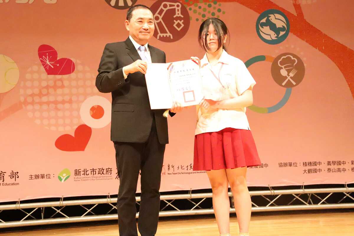 侯友宜(左)頒贈技藝教育績優學生獎項予中和國中9年級同學林玟彤(右)。 圖：新北市教育局/提供