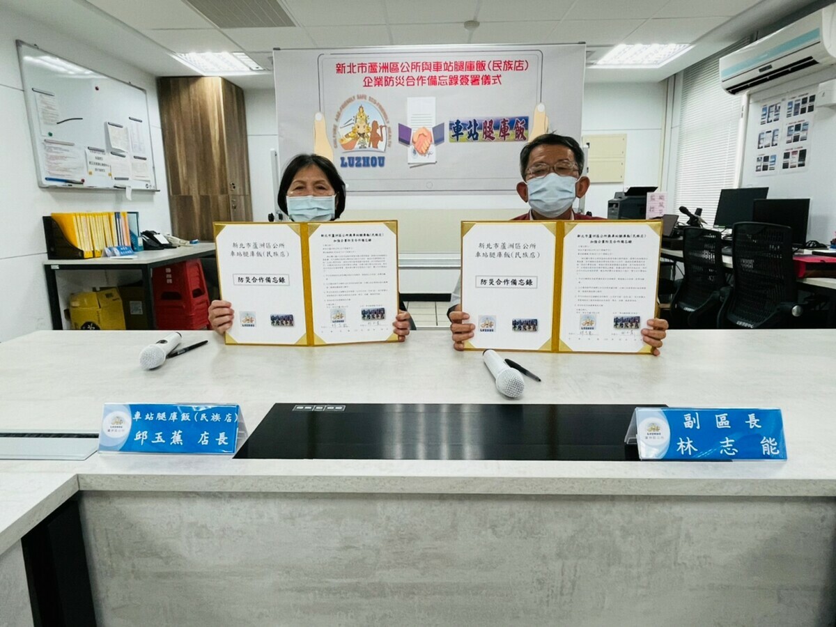 蘆洲區副區長林志能（右）、車站腿庫飯民族店長邱玉燕展示合作備忘錄簽署成果。 圖：蘆洲區公所提供