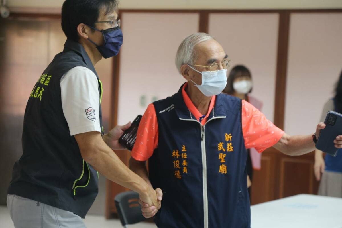 新莊區長朱思戎（左）、武聖廟主委林俊德討論健康醫療活動。 圖：新莊區公所提供