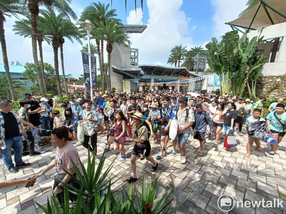 眾多遊客穿著藍白拖、花襯衫享受199入園大優惠。 圖：唐復年/攝