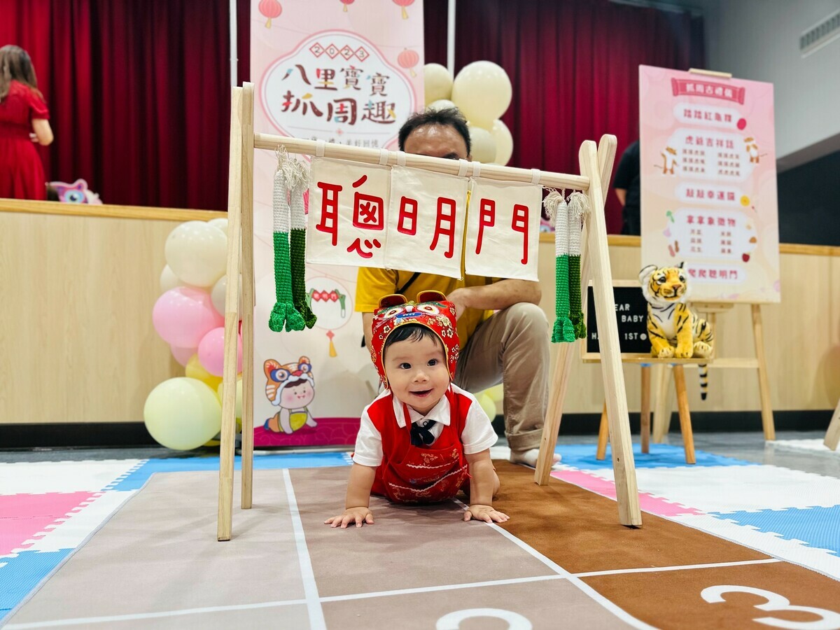 寶寶爬過聰明門，象徵未來人生道路都可以順順利利，聰明過人。 圖：八里區公所提供
