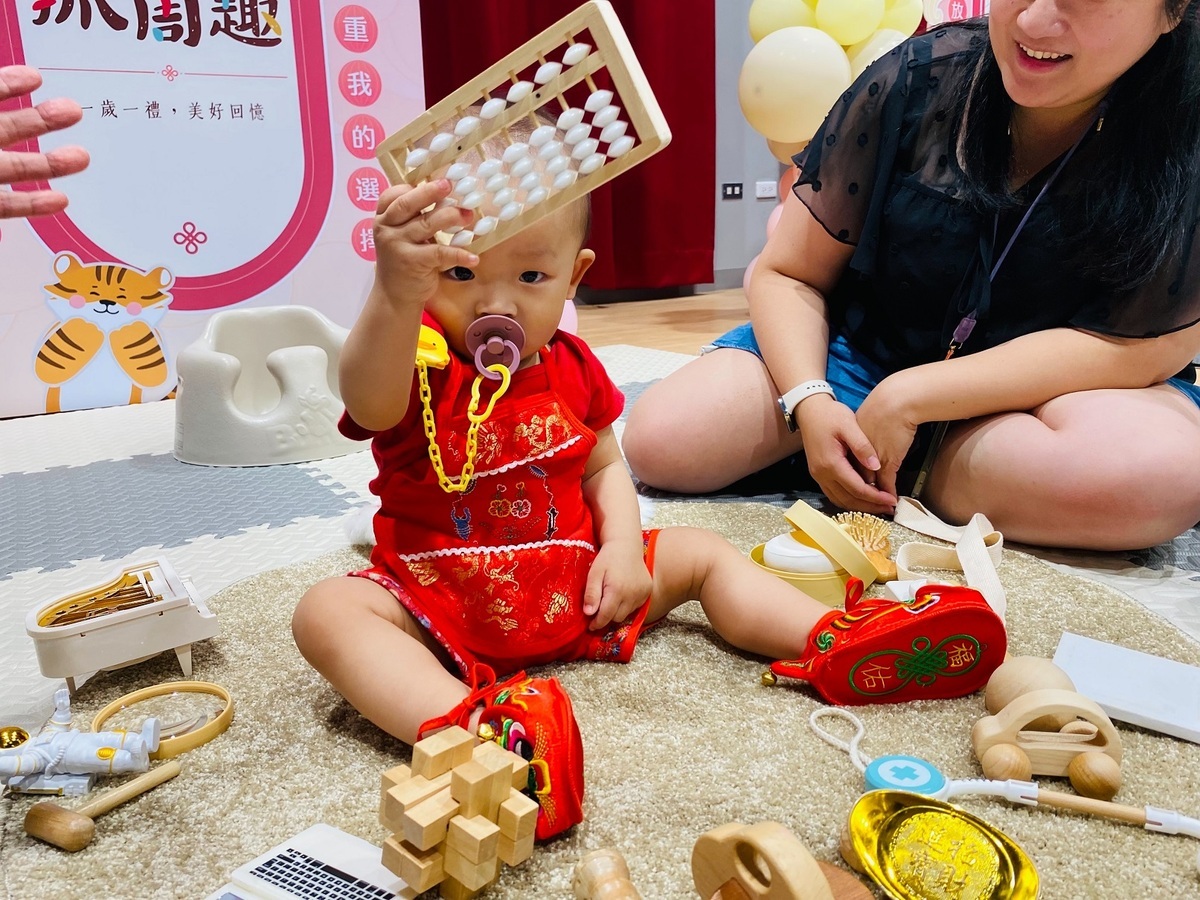 寶寶一把抓起算盤，小小年紀就嶄露出理財管理大師的氣魄。 圖：八里區公所提供