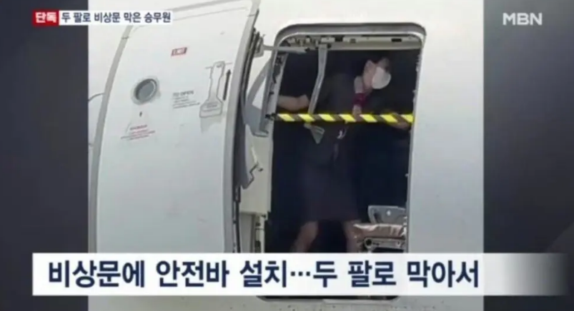 南韓國內線一架客機26日在航行時，艙門被乘客蓄意打開，空姐用身體擋住艙門，疑似是航班降落後的場景。 圖: 擷取自南韓 MBN 電視台畫面