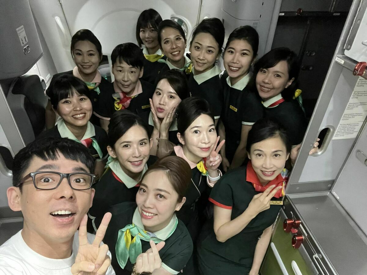 阿滴則被空姐包圍開心合影。 圖：翻攝自FB/阿滴英文