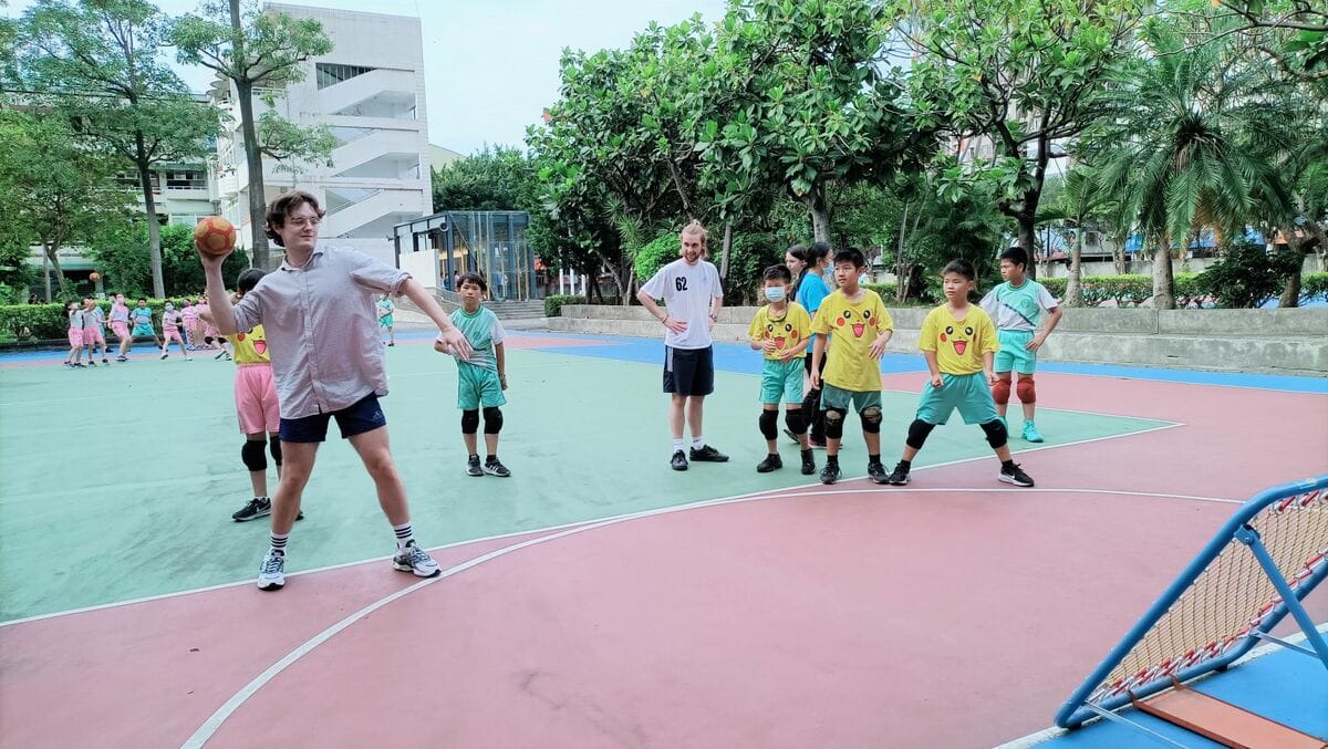 思賢國小學生與淡江大學華語中心外籍大學生一起打巧固球。 圖：新北市教育局/提供