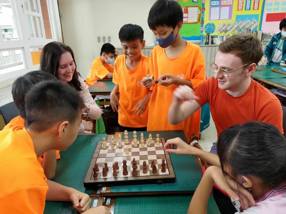 淡江大學華語中心外籍生Owen（右2）向思賢學生介紹西洋棋。 圖：新北市教育局/提供