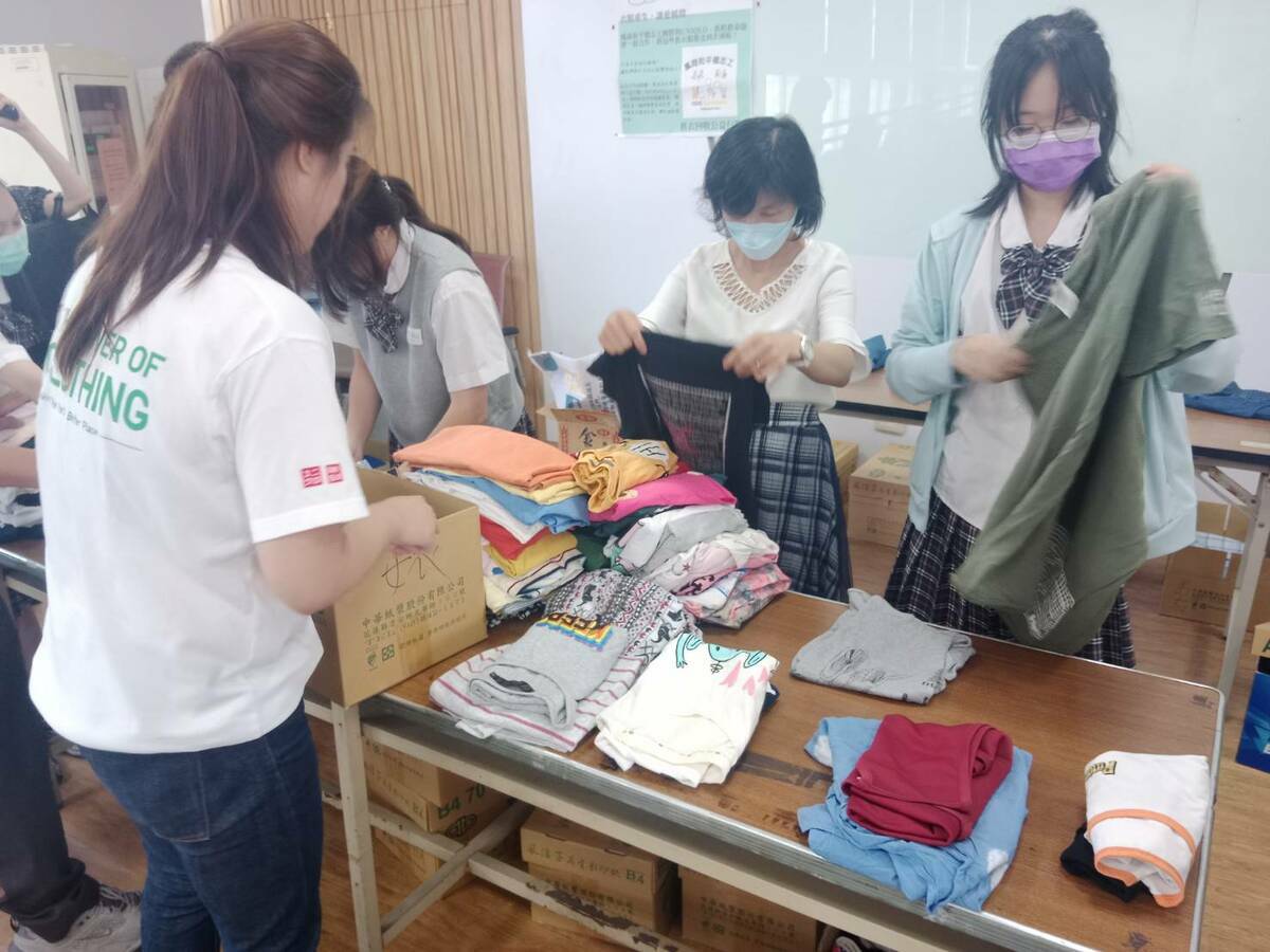 鳳商同學協助整理回收的二手衣。 圖：孫家銘攝