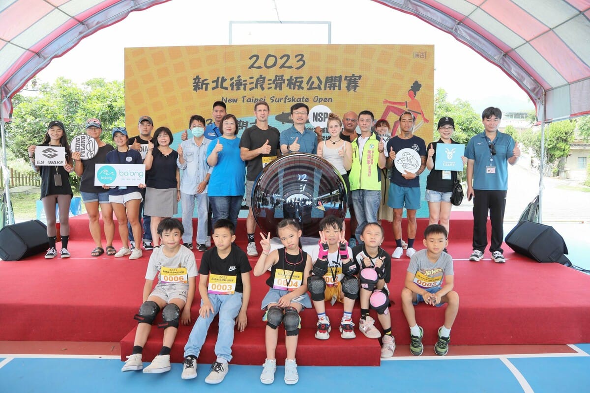 教育局長張明文（中間站立綠上衣)參加2023第1屆新北衝浪滑板公開賽開幕儀式後與來賓、選手合影。 圖：新北市教育局提供