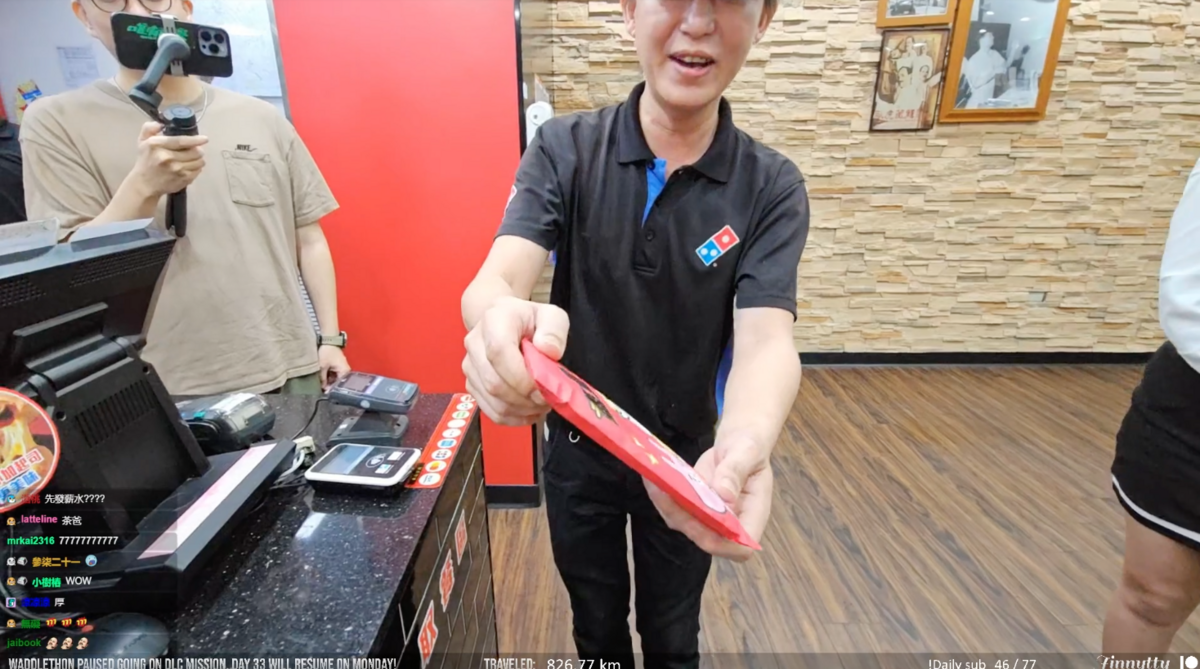 達美樂北區副總拿出「茶爸」預先準備好的超厚紅包送給企鵝妹。 圖：翻攝自Twitch/Jinnytty