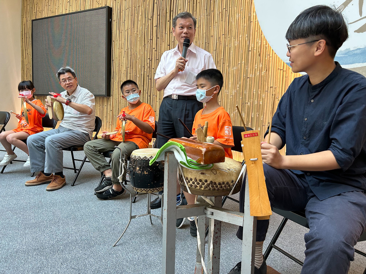 新北市興仁國小校長楊順宇及學童一起與藝師鄭榮興體驗客家八音。 圖：新北市文化局提供