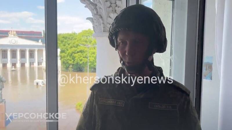 親俄傀儡前赫松州長薩多在鏡頭前接受訪問時聲稱感受不到洪水，他背後窗外則是一片水鄉澤國。 圖：翻攝推特