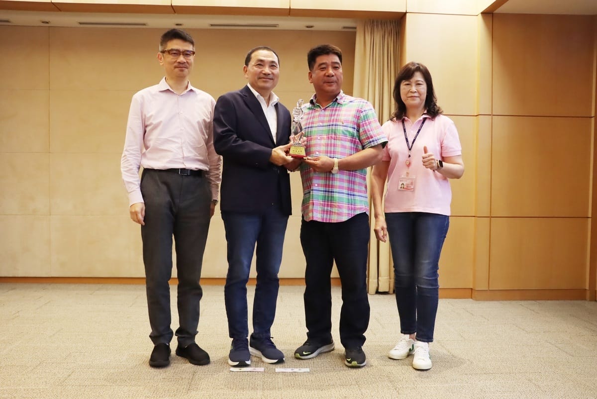 新北市長侯友宜為表揚萬里區漁會卸魚申報有功，特別頒發獎盃與萬里區漁會代表練聰明。 圖：新北市漁業處提供