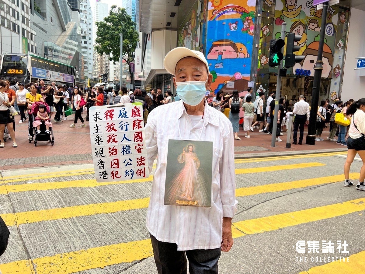 87歲長者在銅鑼灣舉起「廢除國安法、釋放政治犯」的標語被港警帶離了現場。 圖：翻攝集誌社臉書