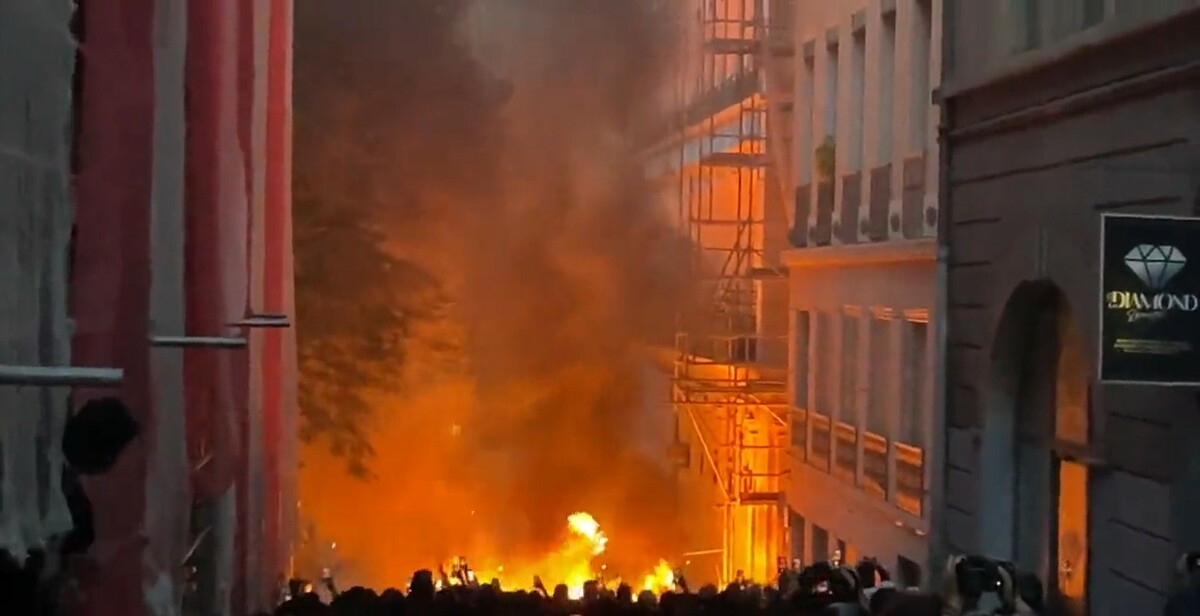 法國某處街道燃燒著大火，濃煙往天空飄散，有些民眾拿起相機拍攝，有些民眾則發出怒火。 圖：翻攝自誰將十萬橫掃三江推特