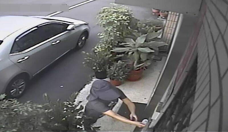 一名刻意戴帽子偽裝的婦人在李天生服務處信箱放置恐嚇傳單。 圖：李天生提供