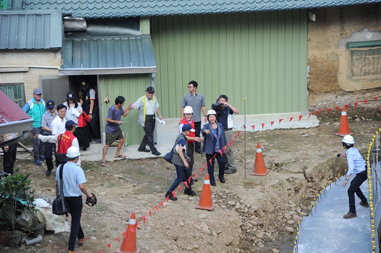 去年梅姬颱風帶來強降雨，造成旗山新光里後厝巷土石崩坍，5戶房屋損壞，高雄市長陳菊視察邊坡崩塌整治及防災整備情形。 圖：高雄市政府