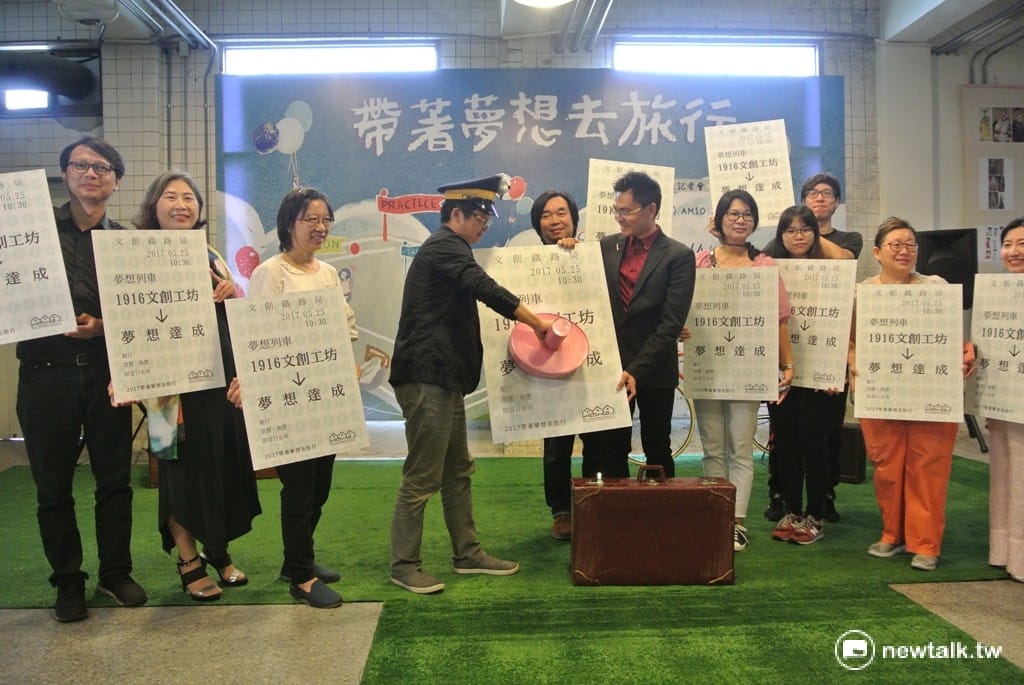 文資局副組長楊宏祥（戴帽者）化身車長，在文創業者手持的大張車票上蓋章，象徵夢想列車啟動。 圖：唐復年/攝