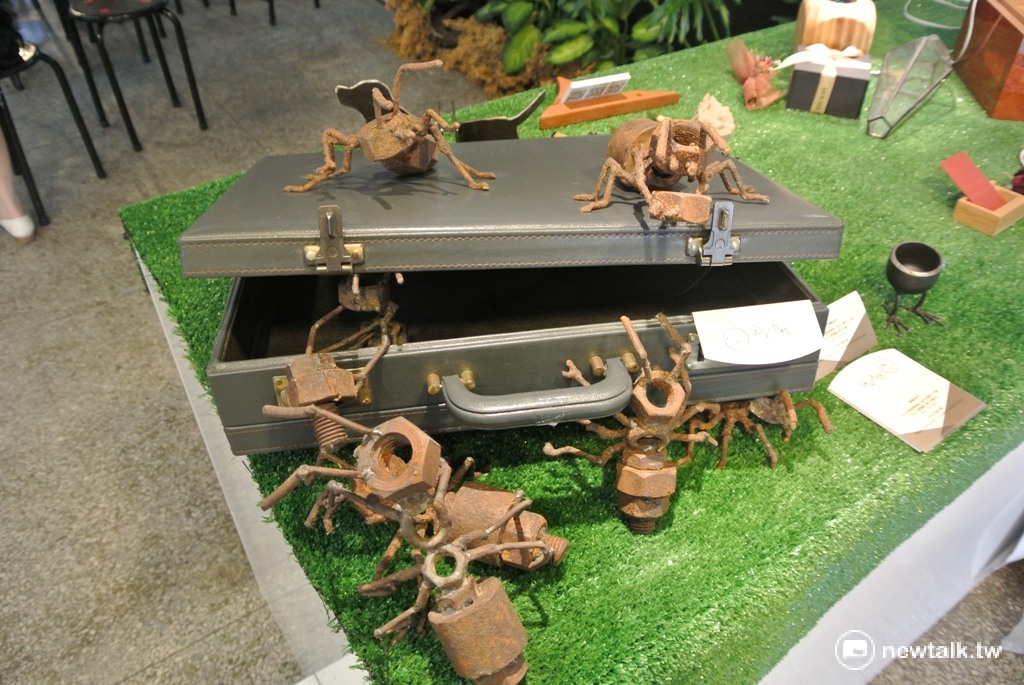 「金呈木作」木質藝品栩栩如生地在皮箱爬上爬下。 圖：唐復年/攝