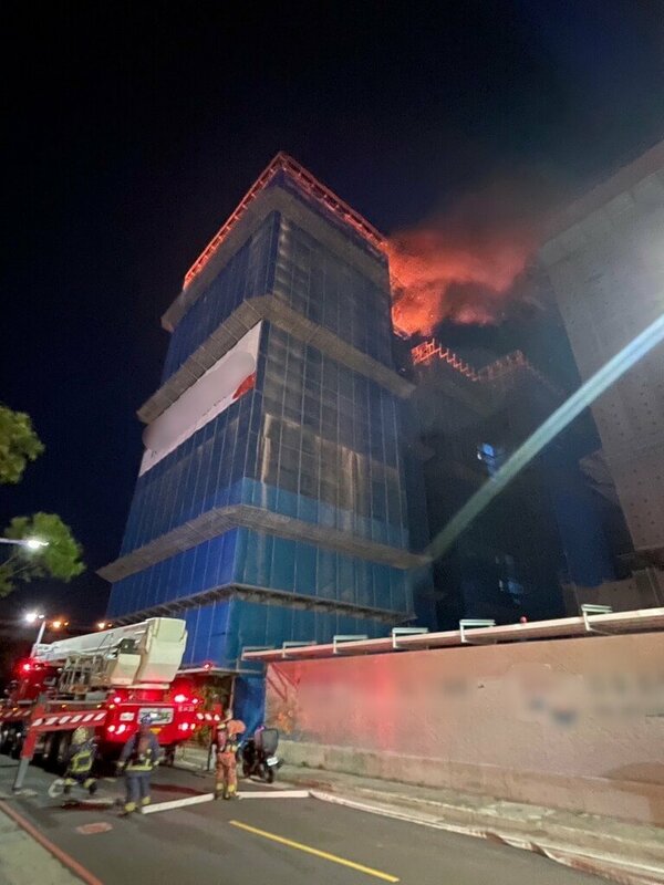 新北市消防局指出，三重區仁義街一處建築工地15日晚間發生火警，建築第14樓全面燃燒，但無人受困，消防人車已到場搶救中。 圖：中央社（新北市消防局提供）