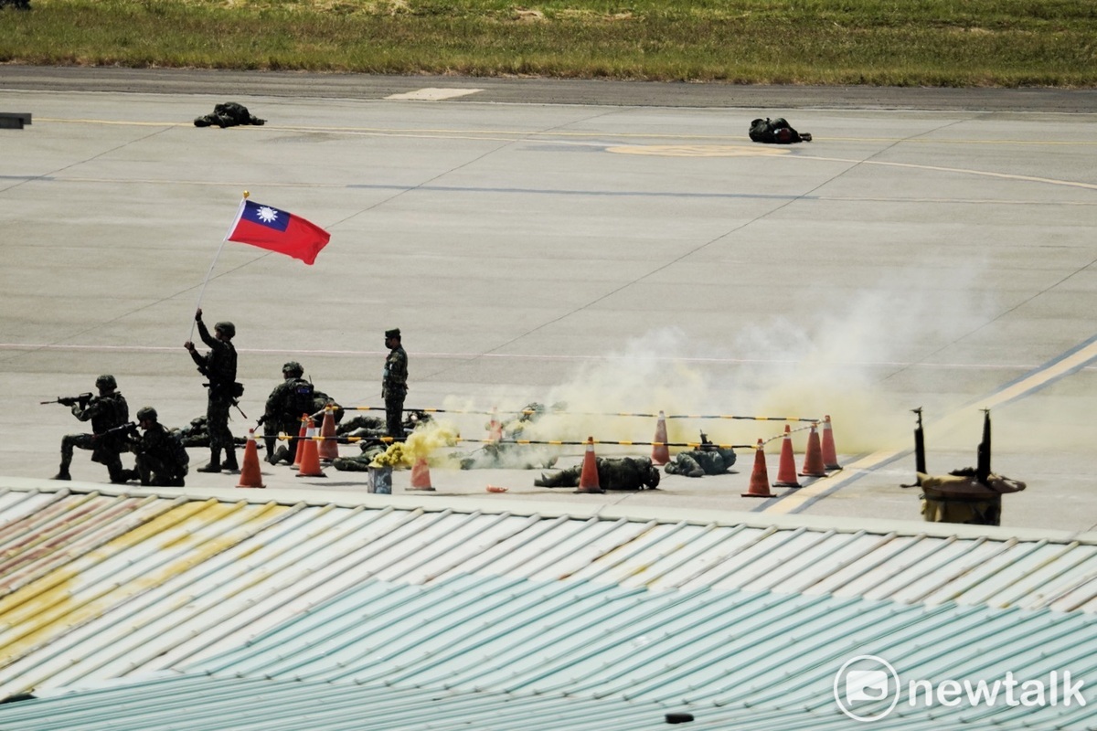 國軍以強大火力壓制來犯的敵特戰人員，並將之殲滅於桃園機喔停機坪後，揮舞國旗。 圖：張良一/攝