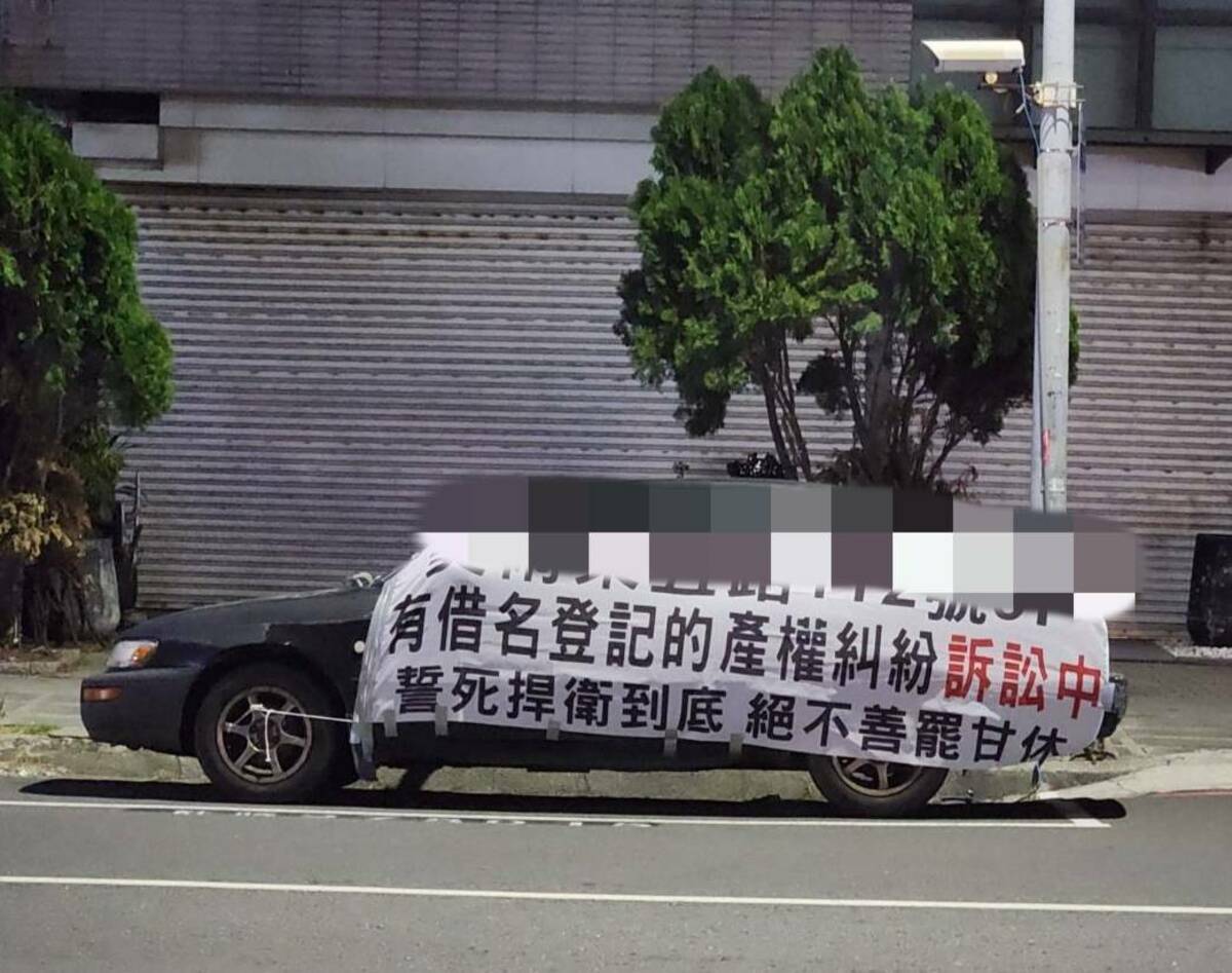鄭為元在車上掛布條提醒房子有產權糾紛。 圖：孫家銘翻攝