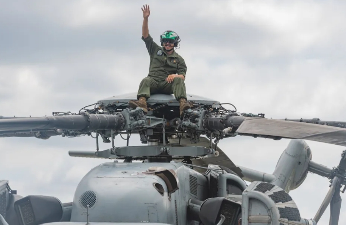 美軍陸戰隊機組員坐在CH-53直升機槳轂上，向參觀民眾揮手致意。 圖 : 翻攝自DVIDS網站