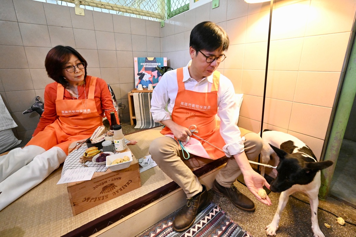 康裕成(左)看著陳其邁親餵毛孩手作雞球。 圖：高雄市政府提供